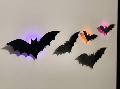 Close-up of bats standing off the wall, violet, orange and pink halos