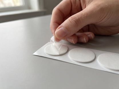 Peeling the film off a round adhesive pad