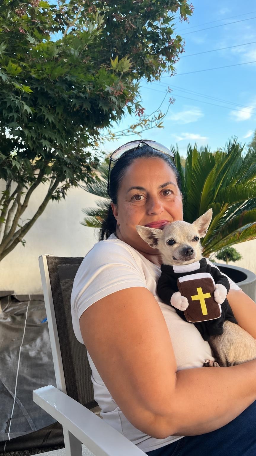 Customer on her patio with her chihuahua in the Holy Priest costume